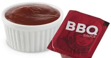 Smoky BBQ sauce served in a cup, perfect for dipping nuggets or fries.