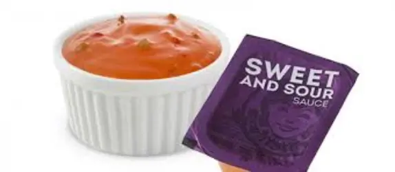 Sweet dipping sauce in a small cup, ideal for pairing with crispy nuggets or fries