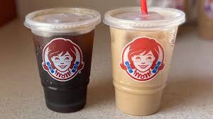 A selection of Wendy’s seasonal frozen drinks, served icy cold in a clear cup for a refreshing treat
